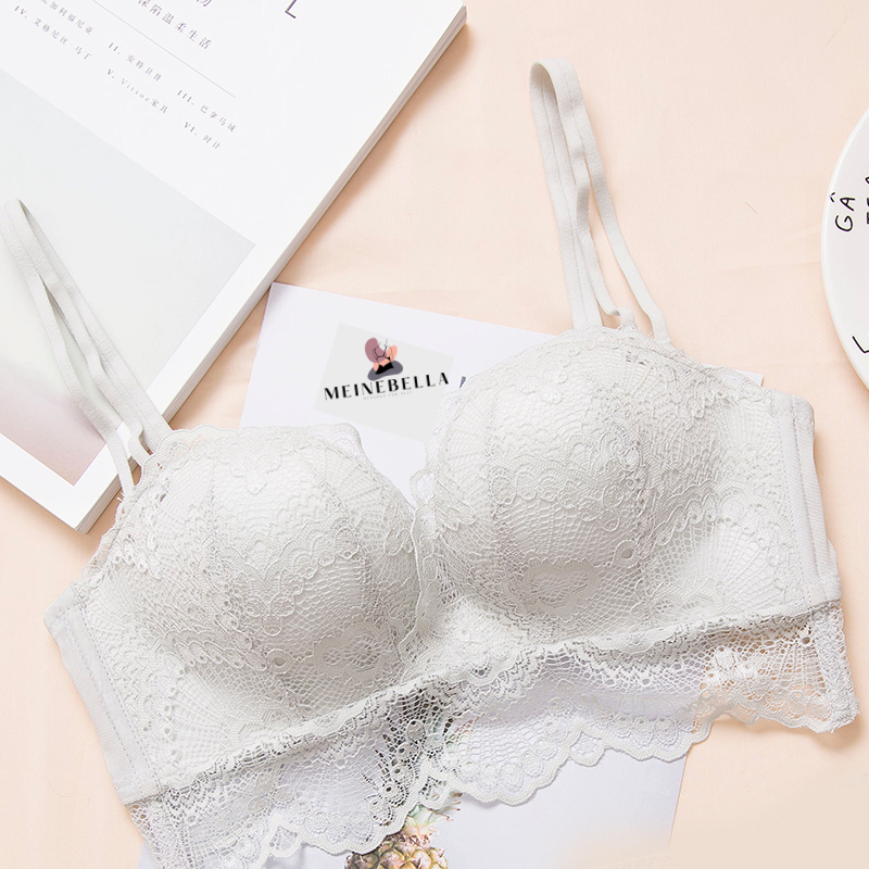 A white lace bra on a soft pink surface.